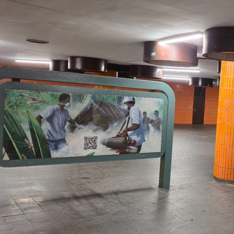 Plant Storage Blick aus einem Baustellenfahrzeug auf einen gepflasterten Weg und einen Teich.